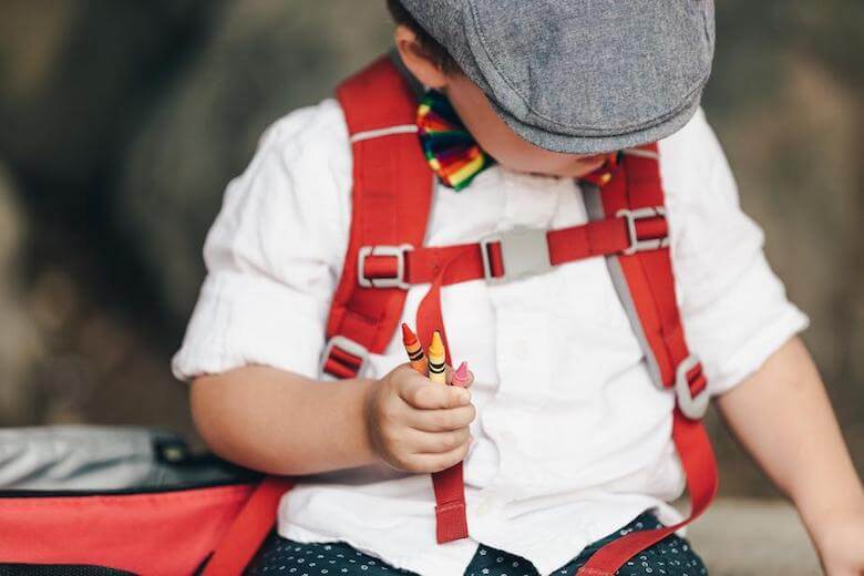 boy holding crayons - cognitive development milestones article image