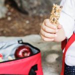 boy hand holding granola bar - food choking hazards at daycare article image