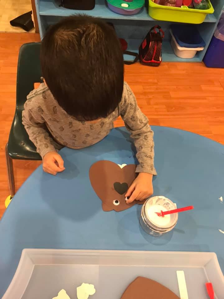 boy making paper beaver craft at daycare
