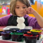 child deciding on paint colours in preschool - what is the third teacher article featured image