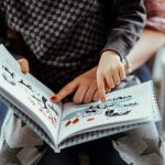 child pointing at book pictures with adult - cognitive development in early childhood article image