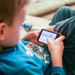 child using phone having screen time - article image for should children use electronics and media