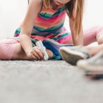 girl drawing on concrete with sidewalk chalk - image for article on benefits of downtime for kids