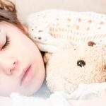 importance of sleep in early childhood article featured image of girl sleeping