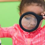 little girl using magnifying glass at metro vancouver daycare centre