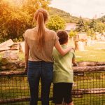mother with child standing at a fence - parent coaching article image