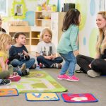 child interacting with teacher at daycare during circle time