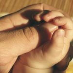 parent and baby hands - article image for government resources for child care