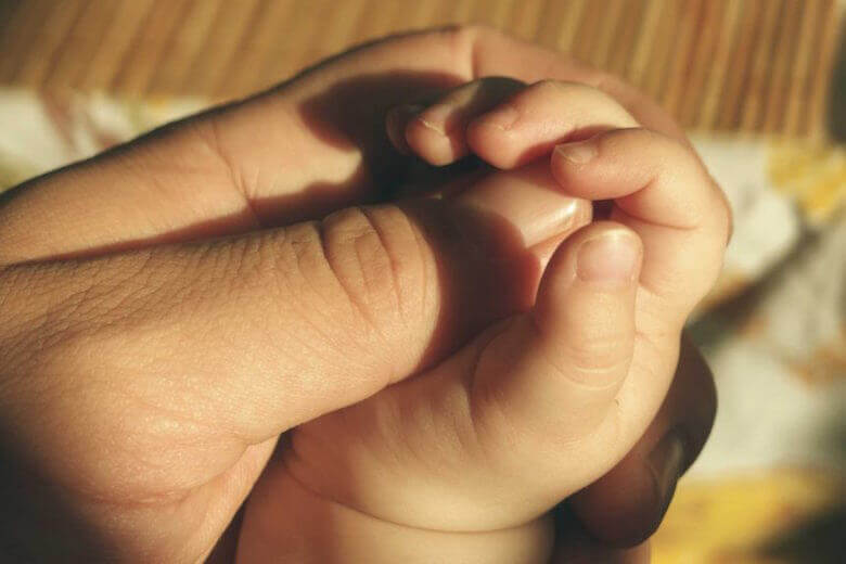 parent and baby hands - article image for government resources for child care 