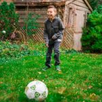 boy playing with soccer ball - image for article on preschool sports ideas