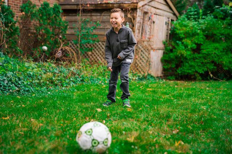 boy playing with soccer ball - image for article on preschool sports ideas