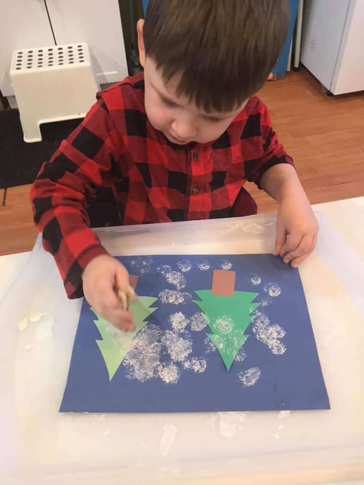 preschool winter craft with snow paint in a christmas tree forest