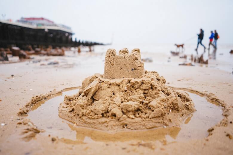 sand castle with moat at the beach - sand game to play with toddlers and preschoolers