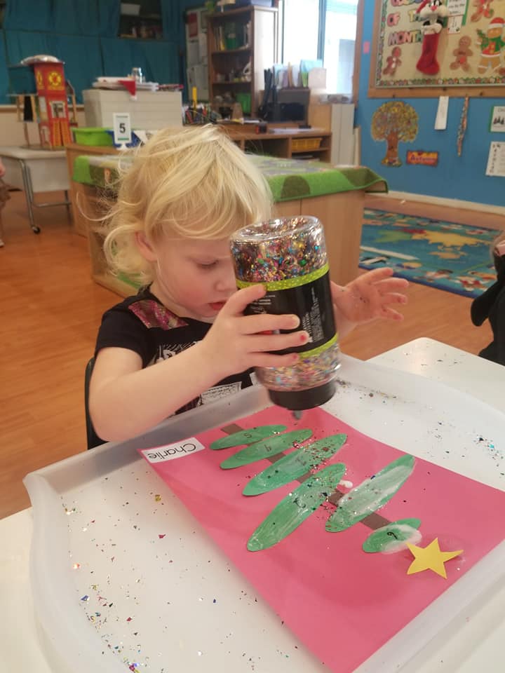 shaking sparkles on a paper christmas tree craft