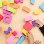 toy blocks and toddler hands - article image on how to teach problem solving skills in early childhood