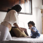 Mom reaching to toddler on bed - sensory disorder article image