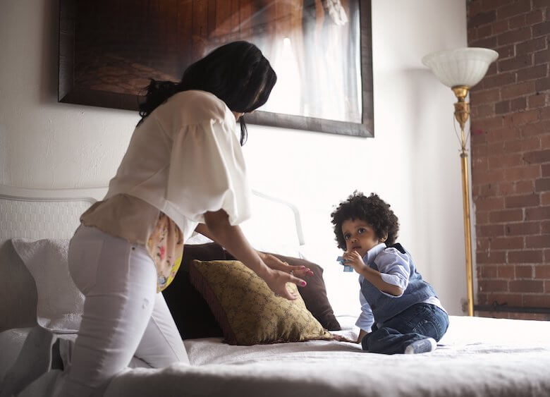 Mom reaching to toddler on bed - sensory disorder article image