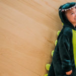 Young boy in dinosaur costume as a dramatic play prop